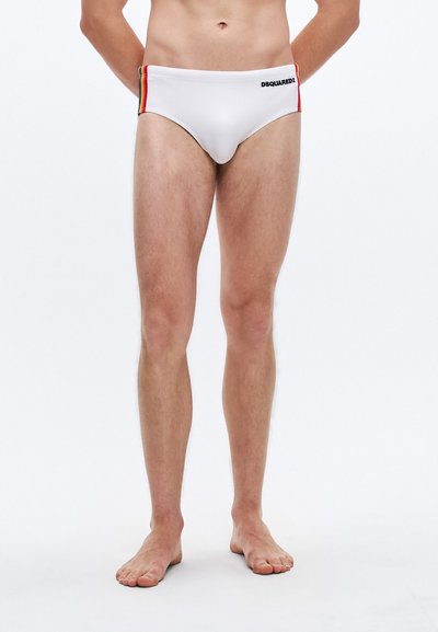 Slip de bain blanc avec des rayures multicolores sur les côtés et le logo "DSQUARED2" noir. Tissu lisse, taille basse, design minimaliste.