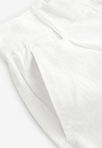 Vita bomullsshorts med en veckad framside-design, sömdekor och en slät textur. Enkel, klassisk skärning med en ren finish.