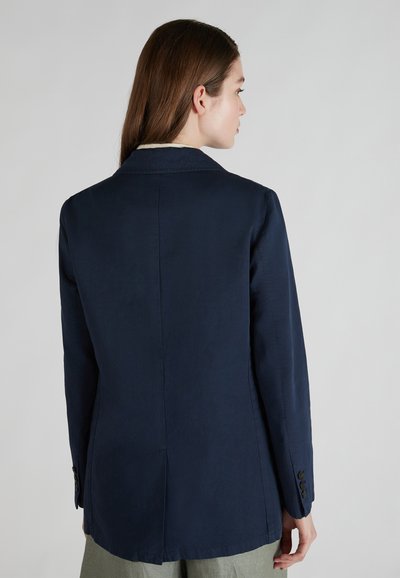 Blazer blu navy realizzato in tessuto liscio, caratterizzato da una singola apertura e maniche con bottone, con una vestibilità sartoriale e cuciture minime.