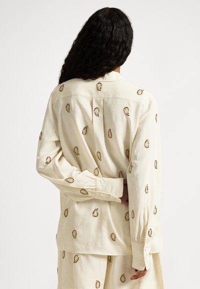 Hemd in Cremefarbe mit goldbestickten ovalen Mustern, lockerem Schnitt, langen Ärmeln und einem Standardkragen.