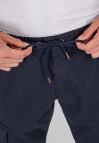 Marineblaue Cargo-Shorts mit elastischem Bund, ausgestattet mit einem Kordelzugverschluss und Kupferakzenten an der Befestigung. Glatte Textur.