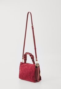 Red suede handbag with a braided top handle, adjustable shoulder strap, and gold hardware accents. Compact rectangular shape.