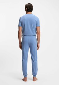 T-shirt bleu clair à manches courtes et pantalon assorti en tissu doux, design ajusté, taille élastique, texture lisse, sans motifs ni accents.