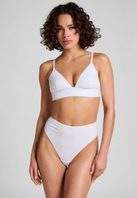 Witte bralette en hoog uitgesneden bikinibroekje gemaakt van zachte stof. De bralette heeft een driehoekig ontwerp met dunne bandjes.