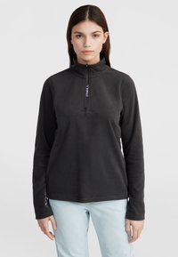 Zwarte fleece pull met een halve rits, met een logo op de kraag en de mouw. Lange mouwen en een zachte structuur.