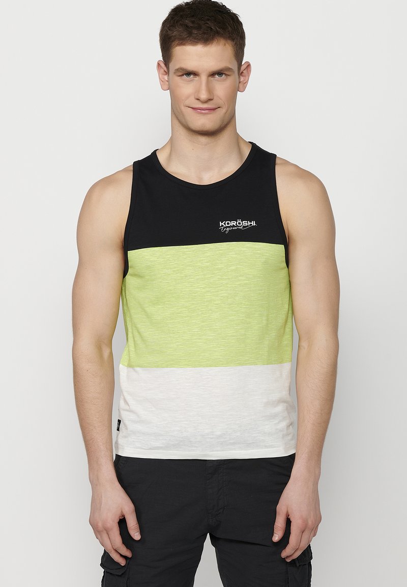 Juoda ir lime žalios juostelės marškinėliai be rankovių su balta apatine dalimi, turintys apvalią iškirptę ir logotipą „KORÖSH“ ant krūtinės.