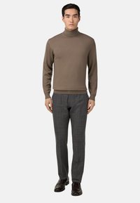 Hnedý rebrovaný rolák skombinovaný so šedými károvanými nohavicami. Hladká textúra a priliehavý strih. Topánky sú z tmavej kože s lesklým povrchom.