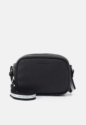 Sac bandoulière noir Calvin Klein Jeans avec forme rectangulaire, fermeture éclair et sangle d'épaule réglable siglée.