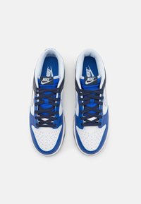 Sneakery Nike mają niebiesko-białą kolorystykę, górną część z gładkiej skóry, perforowany przód, oraz niebieskie sznurowadła na wyściełanym języku.