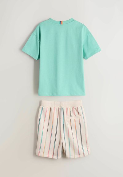 Turkis kortærmet T-shirt med regnbuefarvet mærkat på kraven, kombineret med cremehvide shorts med lodrette multifarvede striber og en baglomme.