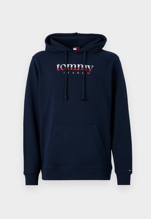 Navy blue hoodie made of cotton, featuring a front pocket and drawstring hood. "tommy" logo in white and red across the chest.
