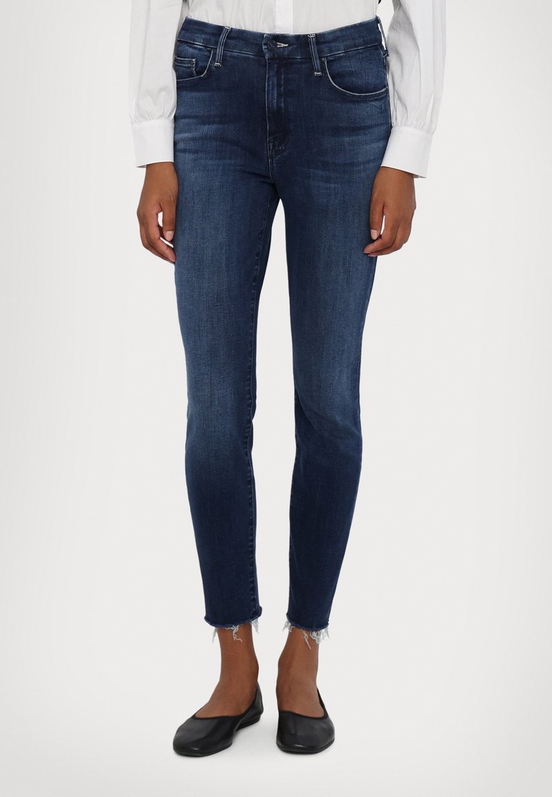 Dunkelblaue Skinny-Jeans aus Denim mit mittlerer Leibhöhe, klassischem Fünf-Taschen-Design und fransenumsäumtem Saum an den Knöcheln.