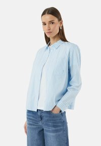 Lichtblauw gestreept overhemd met knoopsluiting, een kraag en een enkele borstzak, gecombineerd met lichtblauwe denim jeans. Soepele stoftextuur.