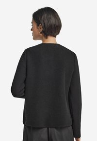 Strikket sort pullovertrøje med en tekstureret overflade, rund halsudskæring og lange ærmer; enkelt design uden synlige mønstre eller accenter.