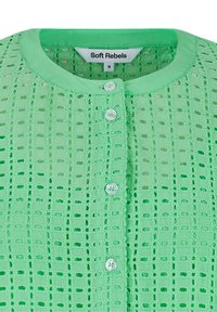 Blouse vert clair à boutons, col rond et motif carré en dentelle, avec de petits boutons blancs sur le devant.