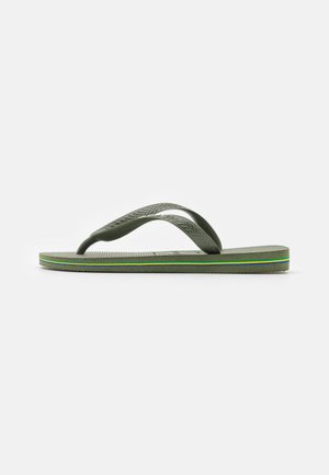Tongs en caoutchouc vert avec des brides texturées, présentant une semelle striée et une rayure multicolore le long de la semelle pour plus de détails.