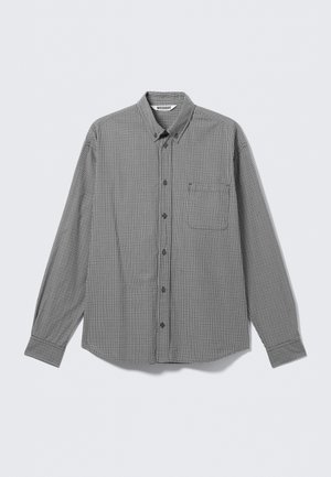 Schwarz-weiß kariertes Hemd mit langen Ärmeln, Knopfleiste, Kragen und Brusttasche, flach auf hellem Hintergrund ausgelegt.