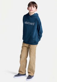 Marineblå bomulds-hoodie med "element"-logo, front-kængurulomme; kombineret med beige fløjlsbukser og grå sneakers.