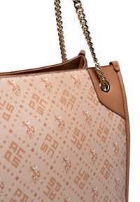 Brun handväska med ett mönstrat kanvasuteroch som har logomotiv. Inkluderar en brun läderdetalj och en metalldelad axelrem.