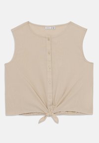 Beige avkappet tank topp laget av mykt stoff, med rund halslinje, knappelukking foran, og en knyttedetalj ved kanten.