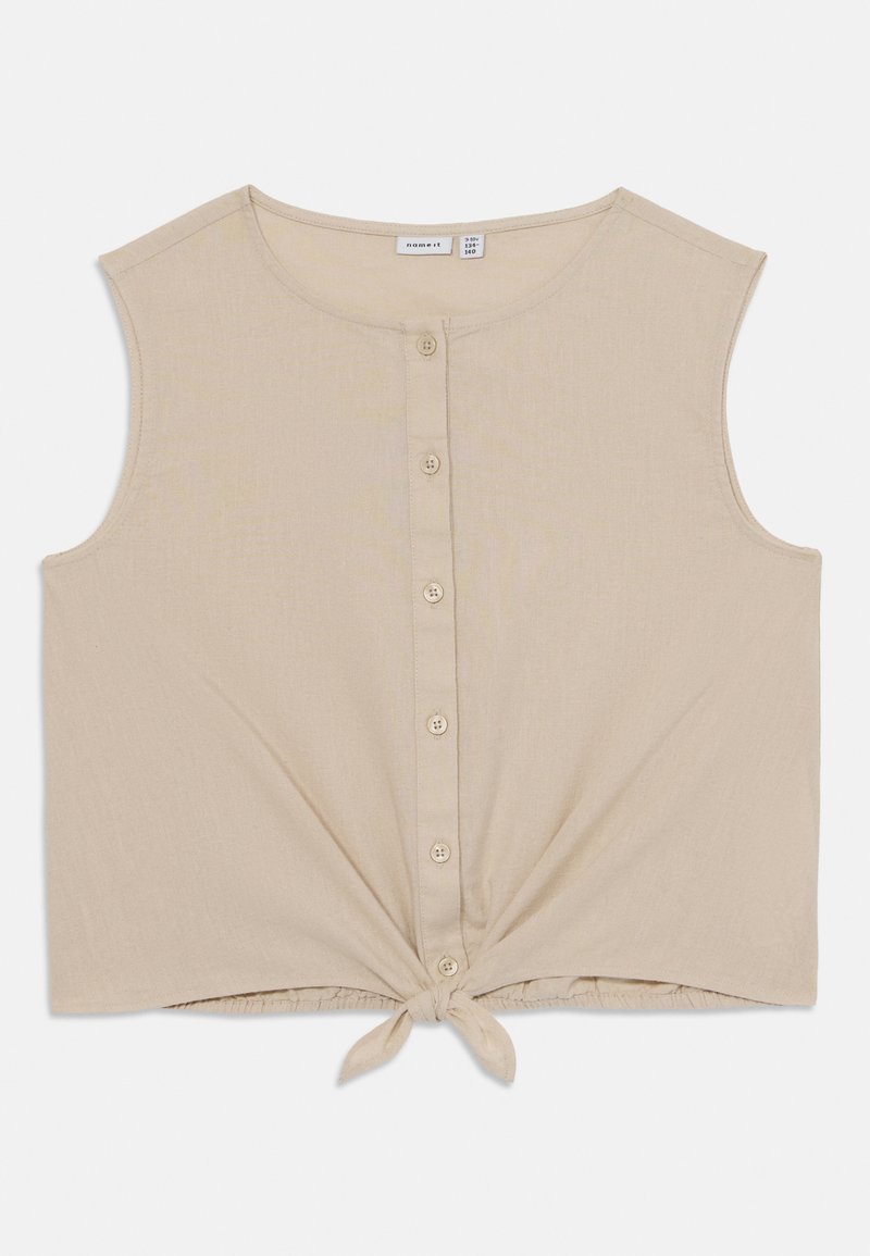 Beige avkappet tank topp laget av mykt stoff, med rund halslinje, knappelukking foran, og en knyttedetalj ved kanten.