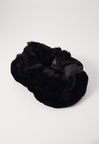 Schwarze Handtasche aus Kunstfell in runder Form, mit einer weichen Textur und einem dekorativen silbernen Knopf. Keine sichtbaren Muster oder Akzente.