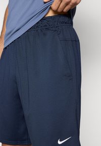 Σκούρα μπλε σορτς Nike με υφή υφάσματος, ελαστική μέση και διακριτικές πλαϊνές τσέπες. Διαθέτουν μικρό λευκό λογότυπο Nike στο πόδι.