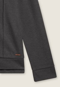 Felpa grigio scuro con texture a costine, polsini aderenti e un piccolo logo in pelle marrone vicino all'orlo. Design semplice, senza motivi.