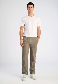 Grijs gestreepte broek met een losse pasvorm, zijzakken, gecombineerd met een effen wit T-shirt en witte sneakers, tegen een effen achtergrond.