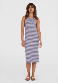 Randig, ribbad stickad klänning i lavendel och vitt, med en figurn�ära silhuett och knälång längd. Buren med vita flip-flops.