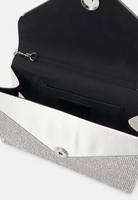 Hõbedase tekstuuriga clutch-kott, valge satiinist klapp ja must sisemus. Omab magnetkinnitust ja sisemist lukuga taskut.