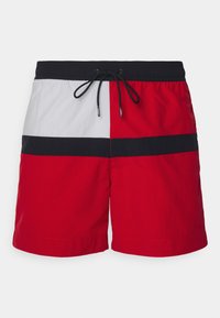 Costumi da bagno a blocchi di colore rossi e bianchi con una vita nera e cordino. Realizzati in tessuto leggero con una trama liscia.