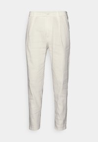 Krémově bílé tailored kalhoty s knoflíkem a zipem, bočními kapsami a zúženým střihem, prezentované na jednobarevném pozadí.