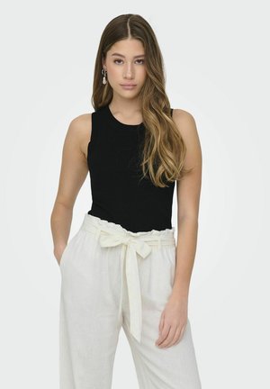 Top de tirantes negro de canalé con escote redondo, combinado con pantalones de lino blancos que cuentan con una cintura atada y un corte relajado.