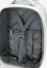 Sac à dos souple gris avec des sangles intérieures et des poches élastiques. Texture de tissu lisse, compartiment principal spacieux et palette de couleurs atténuées.