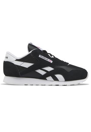 Zapatillas Reebok en blanco y negro que presentan material de ante y malla, puntera redondeada y suela de goma texturizada con acentos de logo.