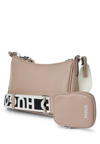 Beige Leder-Crossbody-Tasche mit einem voluminösen schwarz-weißen Riemen, ausgestattet mit einem abnehmbaren Täschchen. Glatte Textur und minimalistisches Design.