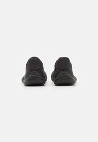 Black athletic shoes featuring a textured upper, cushioned sole, and a streamlined design, with a focus on function and support.