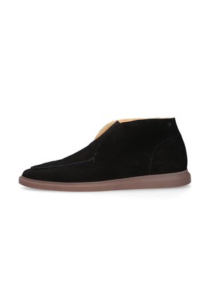 Stivaletto in camoscio nero con suola in gomma marrone, cuciture minime e design semplice, mostrato dal lato esterno su sfondo bianco.