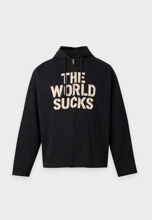 Черна блуза с качулка и цип, с връзки и едър кремав надпис „THE WORLD SUCKS“ отпред.