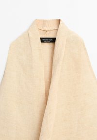Beige linnen blazer met sjaalkraag en zichtbaar Massimo Dutti-label aan de binnenkant van de halslijn, gemaakt in Marokko.