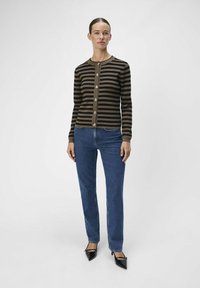 Gestreifter Cardigan in Braun und Schwarz mit rundem Halsausschnitt, Knopfleiste, langen Ärmeln und gerippten Bündchen. Kombiniert mit blauen Jeans.