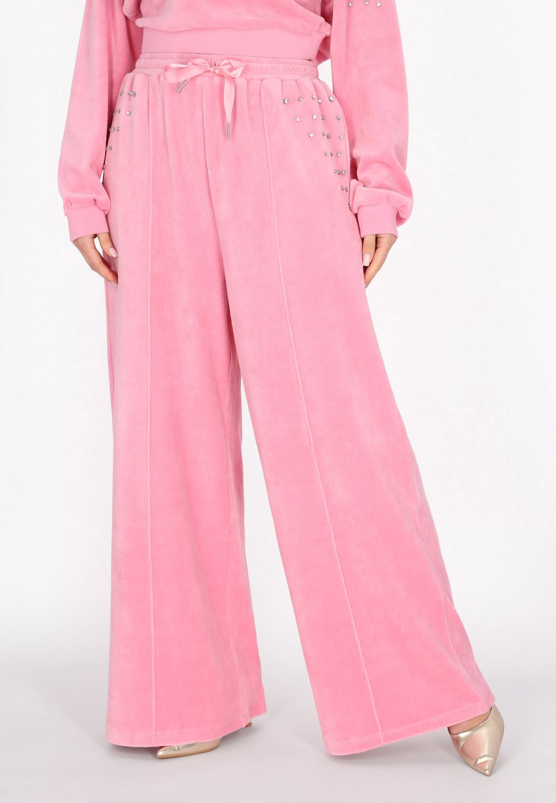 Roze wijde broek van zachte stof, met een elastische tailleband en decoratieve zilveren studs aan de zijkanten, inclusief zichtbare stiknaden.