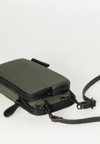 Groene stoffen schoudertas met zwarte ritsen en strap. Heeft een stijlvolle rechthoekige vorm, een gladde textuur en minimale hardware accenten.