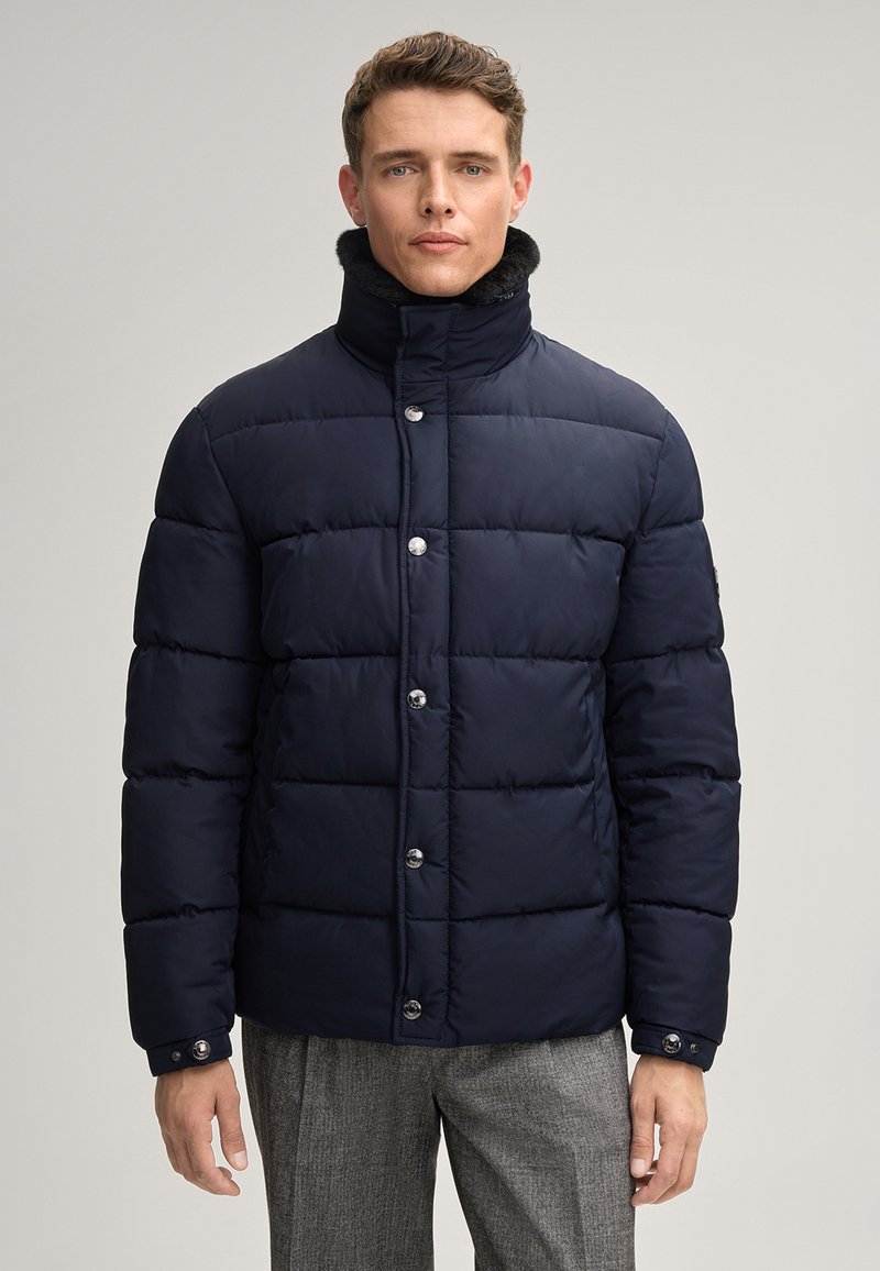 Giacca a vento blu notte realizzata in tessuto imbottito e liscio, con colletto alto e bottoni argentati. Presenta cuciture orizzontali e un design elegante.