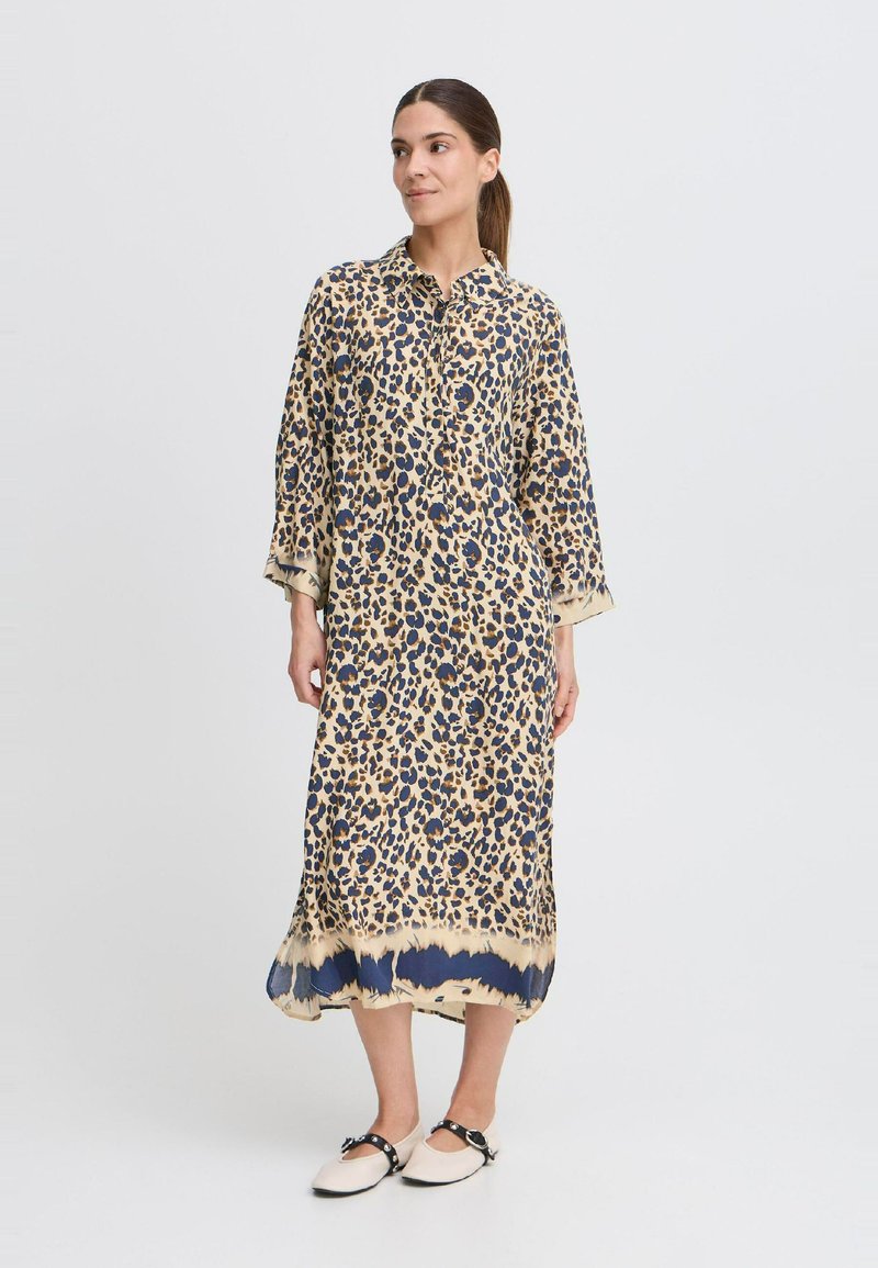Langarmkleid mit Leopardenmuster, Kragen, Dreiviertelärmeln und einem fließenden Saum, der von Beige zu Marineblau am unteren Ende übergeht.