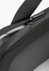 Gray fabric bag with a smooth, textured surface, accented by a black zipper and strap. Features a slim, rectangular shape for compact storage.