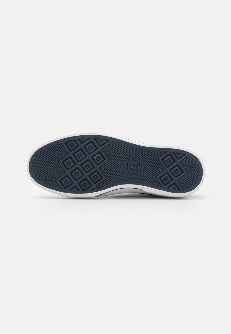 Semelle de sneaker blanche avec un dessous en caoutchouc texturé bleu foncé, comportant des motifs géométriques et un logo au centre.
