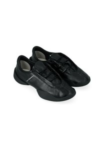 Scarpe in pelle nera con punta arrotondata, dettagli in rete, design snello e finitura testurizzata. Include lacci elastici e suola in gomma.