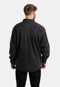 Sort denimskjorte med en afslappet pasform, lange ærmer, knapmanchetter, rygsømsyning og buet kant. Struktureret stof med en afdæmpet finish.